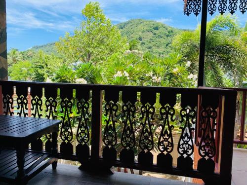 a balcony with a bench and a view of the mountains at Delight Resort in Haad Rin