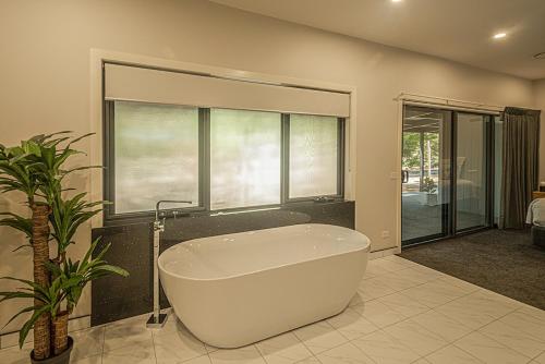 a white bath tub in a bathroom with a plant at Central Views Halls Gap in Halls Gap