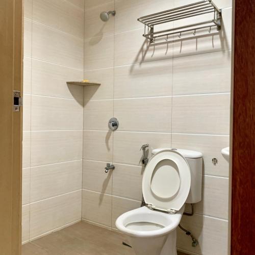 a bathroom with a toilet and a shower at New Grand Hotel in Keningau