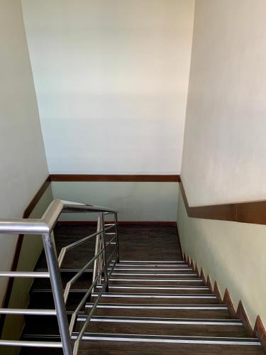a staircase in an empty room with a stair case at New Grand Hotel in Keningau