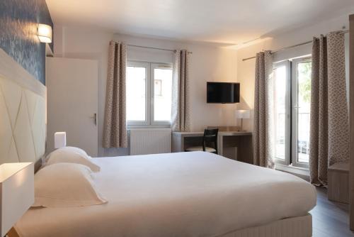 Säng eller sängar i ett rum på Hôtel de l'Orme, Akena