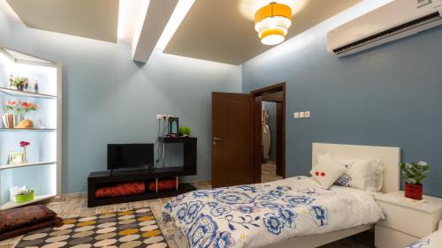 a bedroom with a bed and a flat screen tv at B-LBAIT Yanbu Villa Garden in Madīnat Yanbu‘ aş Şinā‘īyah