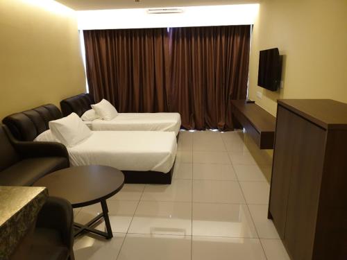 a hotel room with a bed and a couch and a tv at Studio Suite Genting Highland 33 in Genting Highlands