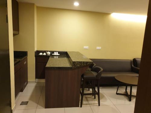 a kitchen with a bar in a room with a couch at Studio Suite Genting Highland 33 in Genting Highlands