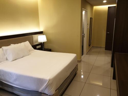 a bedroom with a white bed and a bathroom at Studio Suite Genting Highland 33 in Genting Highlands