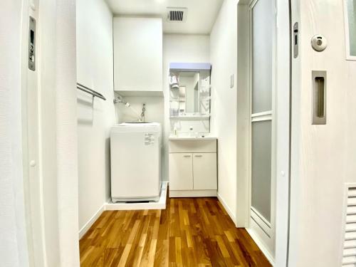 a white refrigerator in a kitchen with a wooden floor at M-Villaggio Miyakojima in Miyako-jima