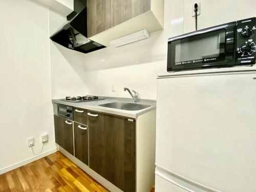 a kitchen with a sink and a microwave at M-Villaggio Miyakojima in Miyako-jima