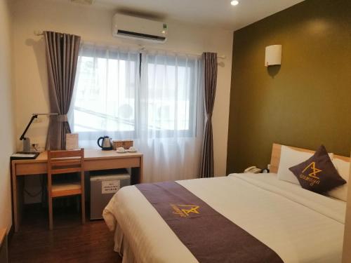 um quarto com uma cama, uma secretária e uma janela em Azumaya Hotel Kim Ma 2 em Hanói