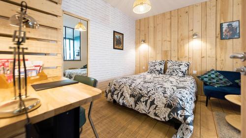 een slaapkamer met een bed en een bureau en een bed sidx sidx sidx bij L'Atelier Corval in Le Mans