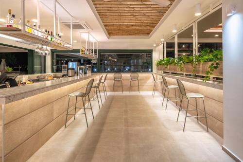 a bar in a restaurant with stools at Iolida Beach by Smile Hotels in Agia Marina Nea Kydonias
