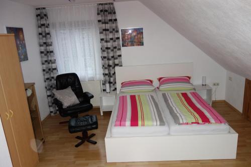 ein Schlafzimmer mit einem weißen Bett und einem Stuhl in der Unterkunft 2 1/2 Zimmer Apartment in Hannover / Nord in Hannover