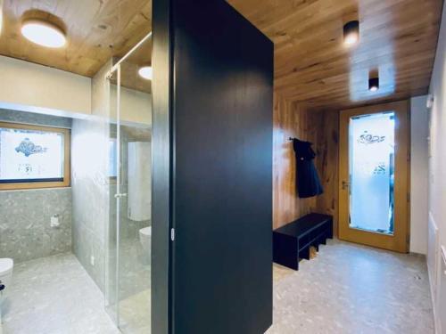 baño con una puerta de cristal que conduce a una ducha en Apartments Cokla Zero, en Zreče
