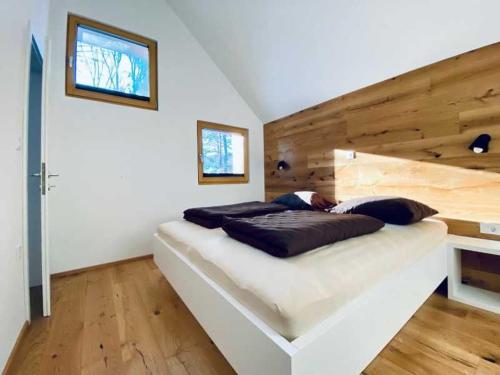 a bedroom with a large bed with a wooden wall at Apartments Cokla Zero in Zreče