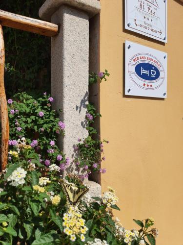 a sign on the side of a building with flowers at AL PEZ exclusive rooms in Olbia