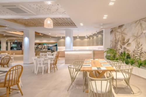 a restaurant with tables and chairs and a bar at Iolida Beach by Smile Hotels in Agia Marina Nea Kydonias