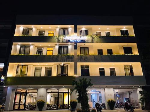 un edificio iluminado por la noche con motocicletas aparcadas delante en Joy Hotel Phú Yên en Tuy Hoa