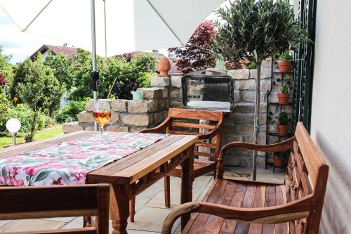 einen Holztisch und zwei Stühle auf einer Terrasse in der Unterkunft Charmante Chiemgauwohnung in Wasserburg am Inn