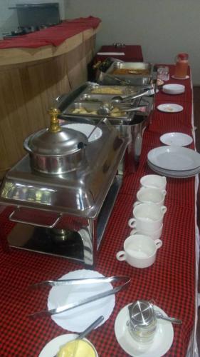 a table with a red table cloth with white plates at New Charity Hotel International in Arusha