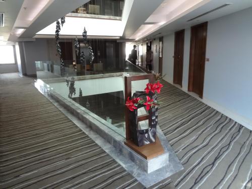 a lobby with a vase with red roses in it at Hotel Suba International Sahar Road Mumbai in Mumbai