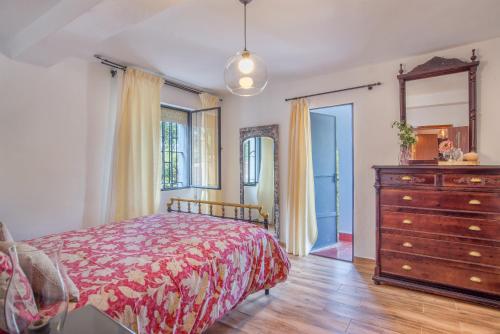 sypialnia z łóżkiem, komodą i lustrem w obiekcie Casa Rural Monte Dios w mieście Jubrique
