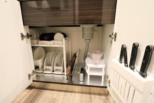 a room with a closet filled with plates and dishes at Smart Stay Ito 301 in Ito