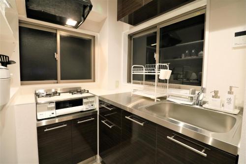 a kitchen with a sink and a stove at Smart Stay Ito 301 in Ito