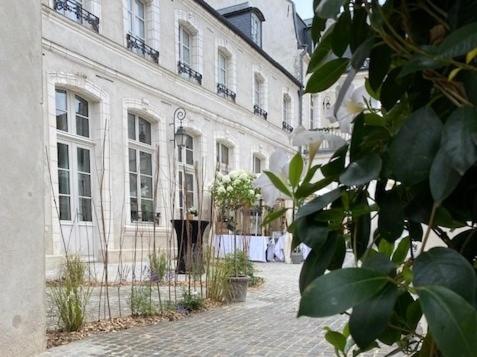 um grande edifício branco com uma cerca em frente em Hôtel Loysel le Gaucher em Montreuil-sur-Mer