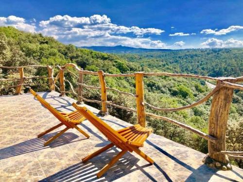 a pair of chairs sitting on top of a viewing deck at Hotel Villa Xtreme in Villa del Carbón