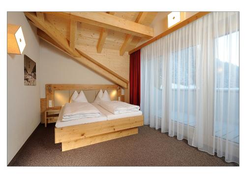 a bedroom with a bed and a large window at Apart Garni Schadhof in Ischgl
