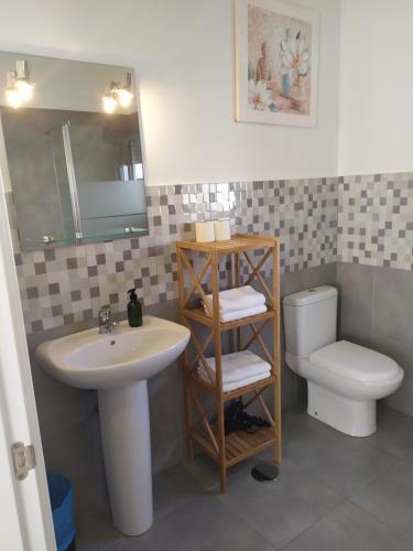 a bathroom with a sink and a toilet at Apartamentos Costa de la Luz Béjar 28-30 in Huelva