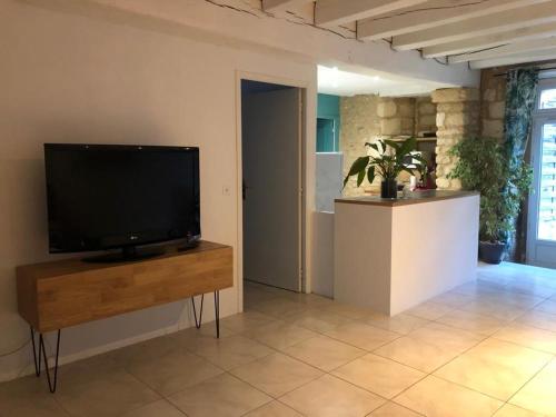 un salon avec une télévision à écran plat sur une table dans l'établissement Appartement 2 personnes Le Bugue Périgord Noir, au Bugue