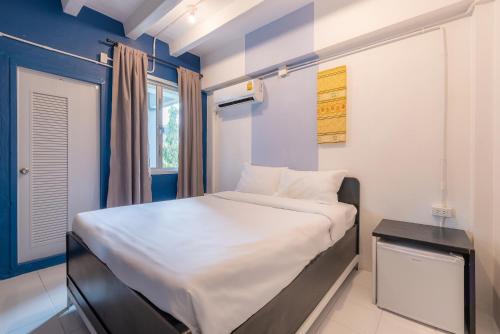 チェンマイにあるBEDGASM Hotel x Cafe Nimmanの小さなベッドルーム(白いベッド1台、窓付)