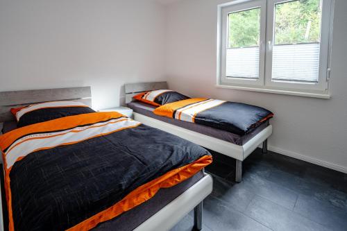 twee eenpersoonsbedden in een kamer met een raam bij AusZeit ! in Wernigerode