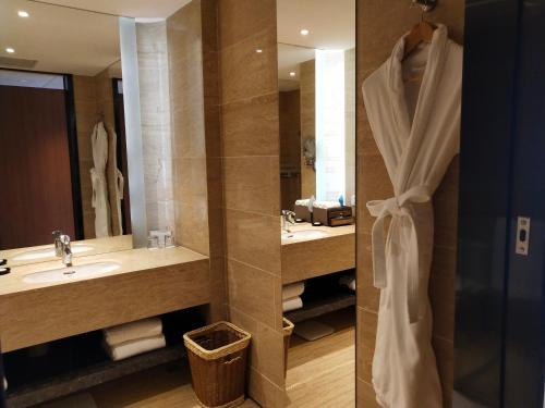 a bathroom with a sink and a mirror and a shower at Marco Polo Parkside, Beijing in Beijing