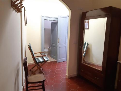 pasillo con espejo y 2 sillas en una habitación en B&B La Locanda en Fiuggi