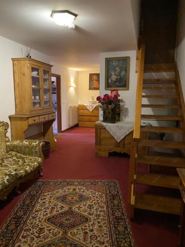 a living room with a staircase and a room with a rug at Hotel Panorama in Cavalese