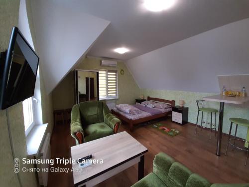 ein Wohnzimmer mit einem Sofa, einem Bett und Stühlen in der Unterkunft Rand in Fontanka