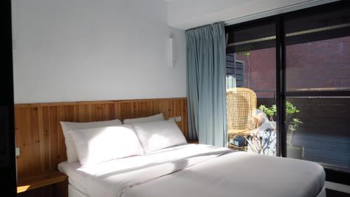 a bed in a room with a large window at Star Hostel Taipei East in Taipei