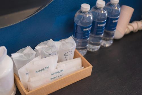 清邁的住宿－BEDGASM Hotel x Cafe Nimman，桌子上装有瓶装水的箱子
