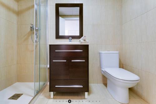 La salle de bains est pourvue de toilettes, d'un lavabo et d'un miroir. dans l'établissement Marina Alicante Apartment - City Center, à Alicante