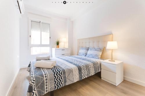 a white bedroom with a bed and a window at Marina Alicante Apartment - City Center in Alicante