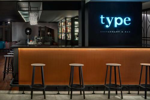 a bar in a restaurant with stools around it at Hermitage Hotel Prague in Prague