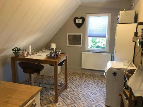 uma cozinha com uma mesa, um frigorífico e uma janela em Ferienwohnung Am Haineberg em Porta Westfalica