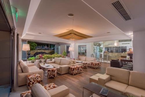 a large living room with couches and tables at Habitat Hotel in Kilkís