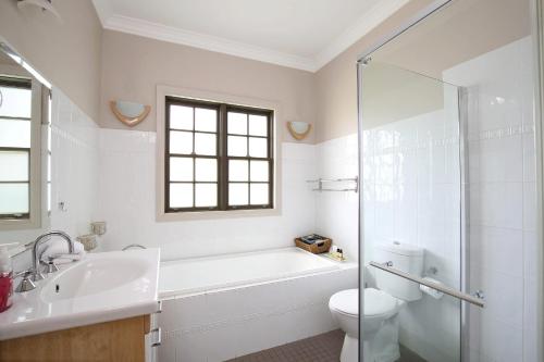 a bathroom with a tub and a toilet and a sink at The Nineteenth in Blackheath