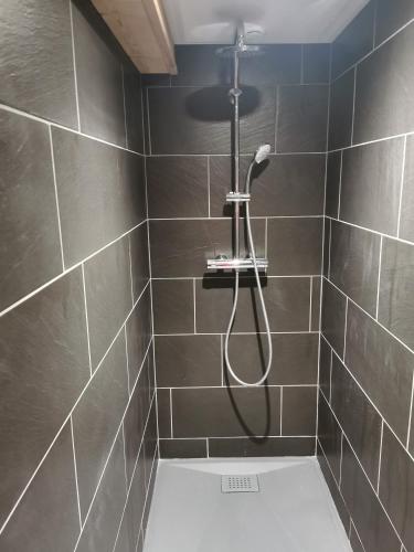 a bathroom with a shower with a black tiled wall at Nouveau Chalet M.META 12 pers sauna,jacuzzi,billard in Xonrupt-Longemer