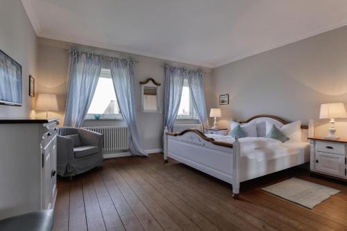 una camera da letto con un letto, una sedia e finestre di Jan´s Hüs a List