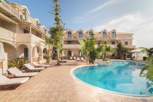 a swimming pool in front of a large building at Pierros Hotel in Laganas