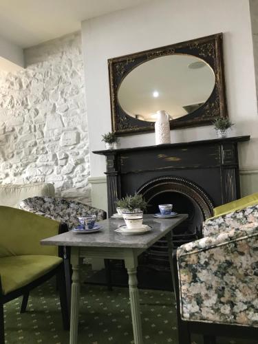 a dining room with a table and a mirror at Falcon Hotel in Carmarthen