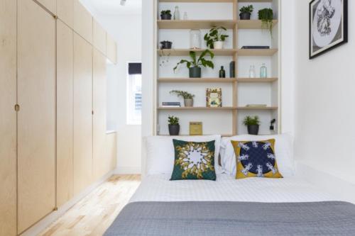 a bedroom with a bed with pillows at Bloomsbury By Viridian Apartments in London